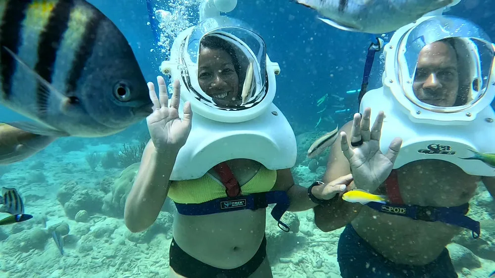 Dos personas con cascos Sea TREK bajo la superficie