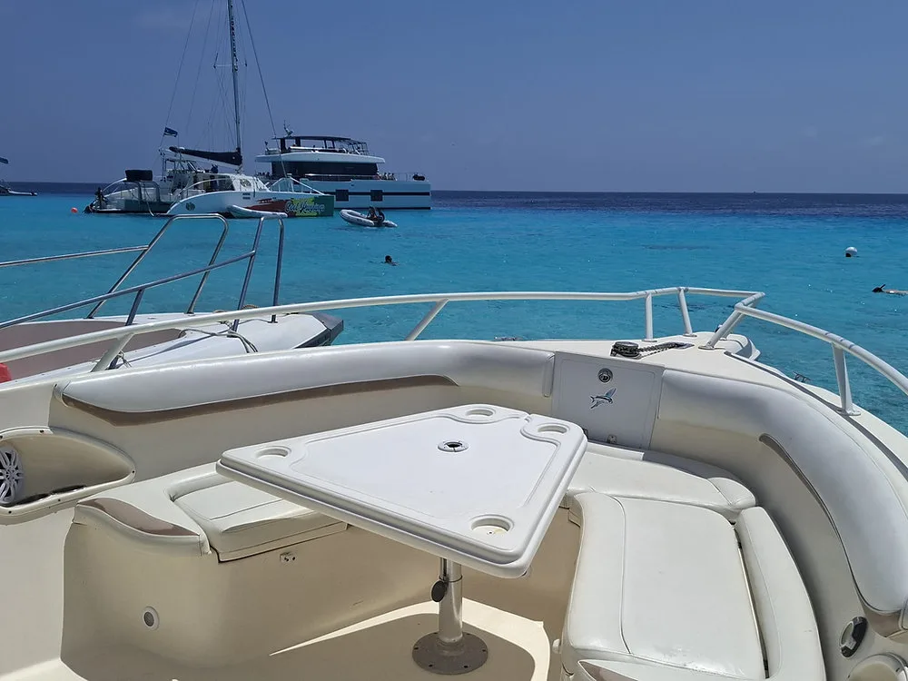 Vista desde los asientos de una lancha hacia aguas azules y barcos fondeados