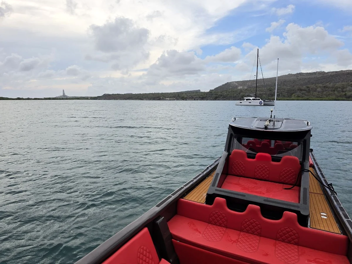 View from the bow across red seats toward the windshield and sheltered bay